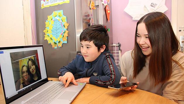Jenni und Collin Nguyen schauen sich immer wieder gerne die Erinnerungsfotos von ihrer Ferienfreizeit an. Foto: Dagmar Besand