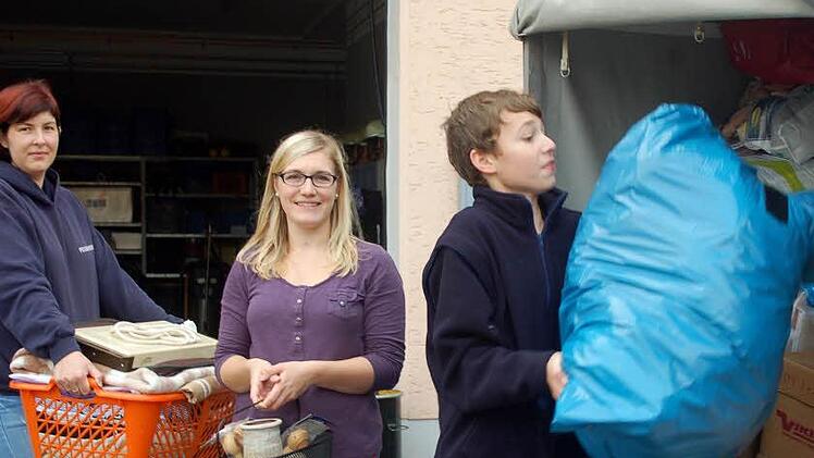 Petra Schumann, Sieglinde Müller und Lars Bütow verladen die Spenden in die Anhänger.