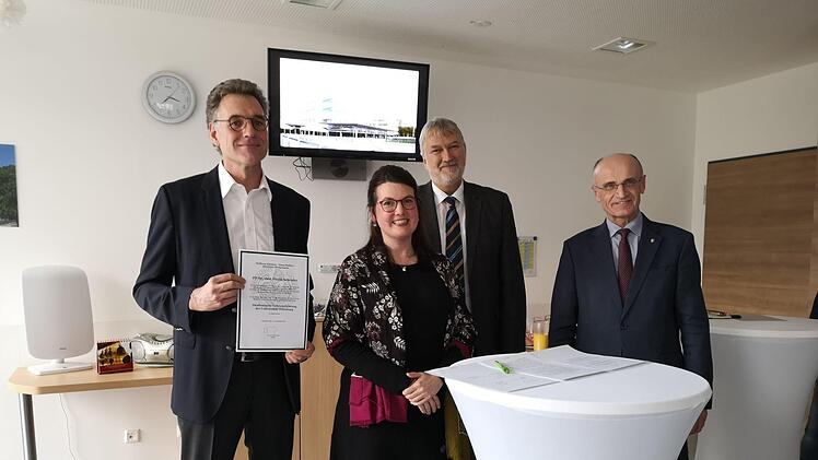 Chefarzt Frank Schröder (links) zeigt die Akkreditierungs-Urkunde der Julius-Maximilians-Universität. Mit im Bild Sarah König, Verwaltungschef Stephan Kolck und  Landrat Wilhelm Schneider. Lucie Homann
