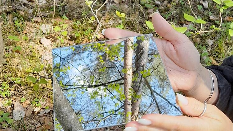 Wenn man den Blickwinkel verändert - wie hier bei dieser Partnerübung mit dem Spiegel - bekommt man oft neue Einsichten. Solche Übungen gehören zur Entspannung im Wald, die Walderlebnisführerin Iris Zehe aus Nüdlingen künftig monatlich anbietet. Foto: Pamela Beer