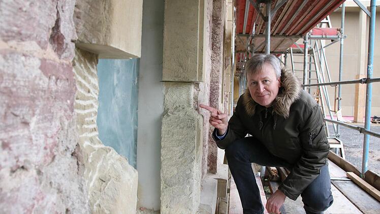 Architekt Ralf Alsheimer zeigt ein Fenstergewände vor der Restaurierung, rechts die Stelle nach der Restaurierung. Foto: Ralf Ruppert