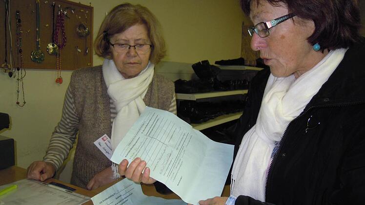 Helga Vierheilig (rechts) mit einer ehrenamtlichen Helferin bei der Durchsicht der Kleiderlisten für die Neuankömmlinge. Foto: Julia Raab
