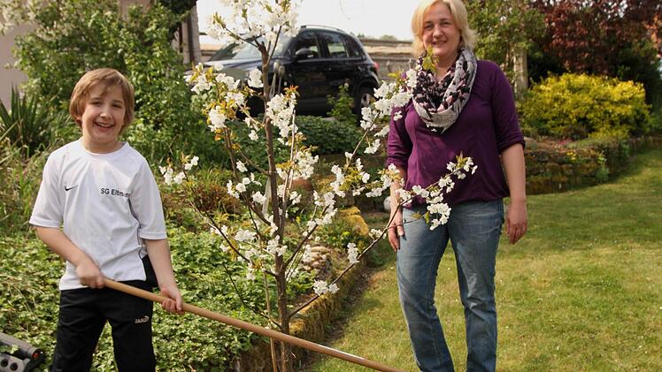 Diana Stark-Heil mit ihrem Sohn Paul im blühenden Garten bei einer Edelkirsche. Fotos: Günther geiling