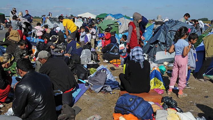 Menschen stehen am 08.09.2015 im Flüchtlingslager von Rözske in Ungarn. Die Zustände sind schlecht. Foto: Peter Zschunke/dpa