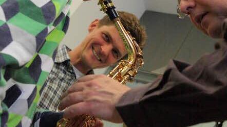 Erstes Erfolgserlebnis: Mit Unterstützung von Musiker Uwe Gutberlet entlockt der achtjährige Paul aus Coburg dem Saxofon eine erste Tonfolge.  Foto: Katja Nauer