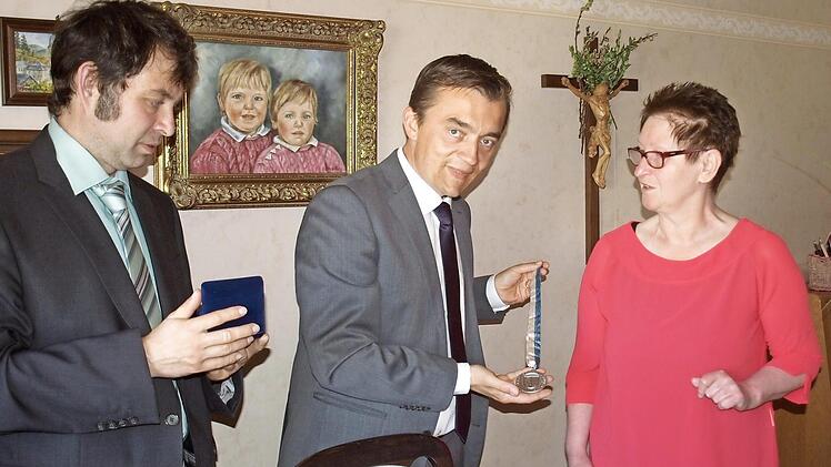 Bürgermeister Jens Korn (Mitte) überreicht Gisela Neuner-Leipold die Silberne Bürgermedaille der Stadt Wallenfels. Links dritter Bürgermeister Andreas Buckreus. Foto: Susanne Deuerling