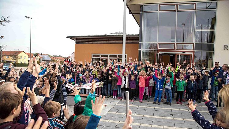 Vor dem Rathaus gingen bei dem  kleinen Festakt viele Kinderhände hoch.privat