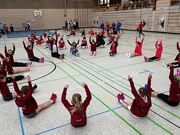 Während sich Miriam Müller (weißes T-Shirt) mit den Turnerinnen aufwärmt, macht Steffi Santjer (schwarzer Anzug) mit den Leichtathleten Übungen. Fotos: Peter Müller