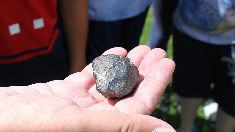 Harro Preiss zeigt den Kindern aus Heiligenstadt seinen Meteoriten, den sein Vater vor vielen Jahren gefunden hatte. Foto: Carmen Schwind