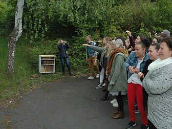 Die Schule der GGSD Coburg gestaltete etliche Lebensräume für die unterschiedlichsten Insektenarten und bewarf ein Grundstück mit Samenbomben. Im Hintergrund ist die Lehrkraft Petra Schreiner (links) neben dem Insektenhotel und vielen Schülern zu sehen. Foto: Edwin Meißinger