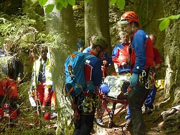 Die Einsatzkräfte der Bergwacht müssen sich ihren Weg zum Verletzten bahnen und diesen sicher aus dem Gelände bergen.