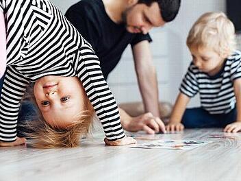 So k&ouml;nnte es funktionieren: W&auml;hrend das M&auml;dchen &Uuml;bungen auf dem Boden macht, spielt der Vater mit dem anderen Kind.  Foto: Michaela Scherer