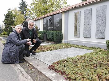 Anne Bergen und Michael Maisch vom Hospizverein Bamberg entzünden ein Licht an der Grabanlage, in der Menschen beigesetzt werden, die einsam und meist mittellos gestorben sind. Foto: Matthias Hoch