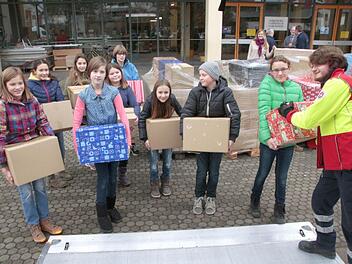 Nur ein paar der 300 Pakete sind noch nicht auf Paletten gestapelt. Sie nimmt der Helfer der Johanniter (rechts) entgegen.  Foto: Josef Hofbauer