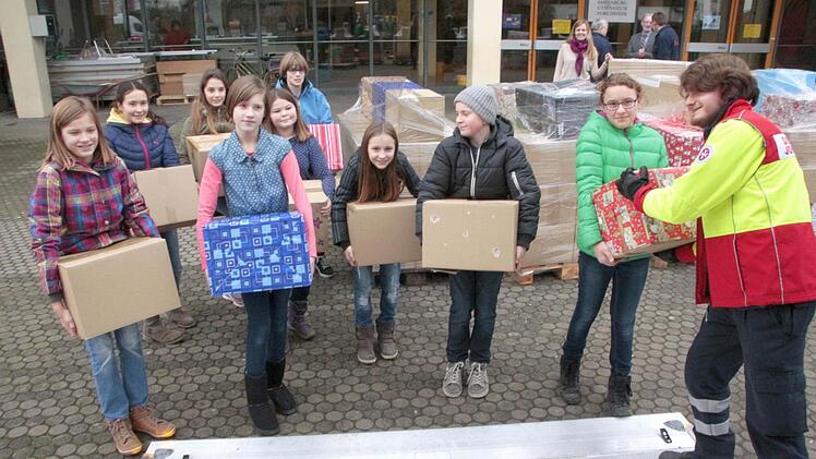 Nur ein paar der 300 Pakete sind noch nicht auf Paletten gestapelt. Sie nimmt der Helfer der Johanniter (rechts) entgegen.  Foto: Josef Hofbauer