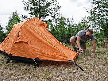Ein Mann schl&auml;gt auf dem Trekkingplatz Frankenwald Kobach sein Zelt auf. Im Frankenwald und im Bayerischen Wald kann man an einigen Orten abseits regul&auml;rer Campingpl&auml;tze zelten. Dies soll bald auch in der Rh&ouml;n m&ouml;glich sein.
