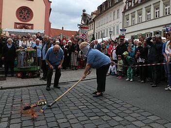 Beim Hahnenschlag zeigte sich Marita Spörlein treffsicher, trotz verbundener Augen. Das Spektakel vor der Elisabethenkirche ist ein Publikumsmagnet. Foto: Harald Rieger