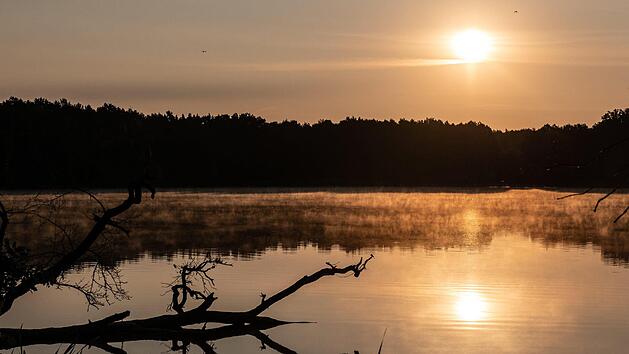Symbolbild: Die Sonne geht &uuml;ber dem Grabowsee in Oranienburg (Brandenburg) auf. Foto: Paul Zinken/dpa