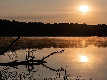 Symbolbild: Die Sonne geht über dem Grabowsee in Oranienburg (Brandenburg) auf. Foto: Paul Zinken/dpa
