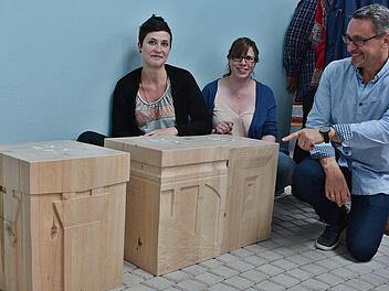 Sophia Keidel und Sabrina Angerbauer zeigen, gemeinsam mit Schulleiter Fred Rottenbach, die neuen Holzstühle, die in der Autobahnkirche "Thüringer Tor" stehen. Sie tragen alle Motive der verschiedenen Brücken an der A 71.  Foto: Hanns Friedrich