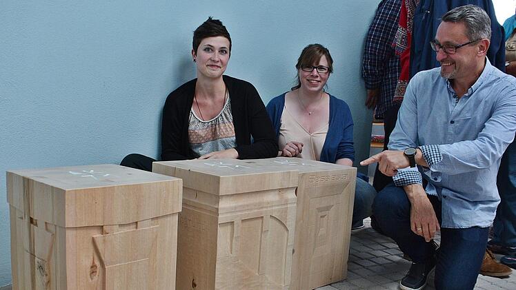 Sophia Keidel und Sabrina Angerbauer zeigen, gemeinsam mit Schulleiter Fred Rottenbach, die neuen Holzstühle, die in der Autobahnkirche "Thüringer Tor" stehen. Sie tragen alle Motive der verschiedenen Brücken an der A 71.  Foto: Hanns Friedrich