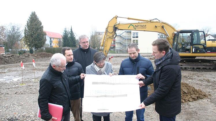 Einen Blick darauf, wie das jetzt leere Gel&auml;nde in der Max-Roesler-Stra&szlig;e im Herbst 2020 aussehen soll, warfen K&auml;mmerer Michael Fischer, Architekt Martin G&ouml;hring,   Gesch&auml;ftsf&uuml;hrer Rainer Mayerbacher (Wohnungsbaugesellschaft), Regierungspr&auml;sidentin  Heidrun Piwernetz,  stellvertretender Landrat Rainer Mattern und B&uuml;rgermeister Tobias Ehrlicher (von links). Foto: Martin Rebhan