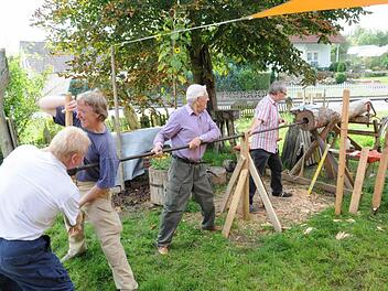 Mit viel Kraftaufwand waren die Mitarbeiter des Arbeitskreises "Heimat und Geschichte"mit dem Durchbohren des Stames beschäftigt, der jetzt den Erlebnisweg "Natour Haßberge" bereichert. Foto: Gerold Snater
