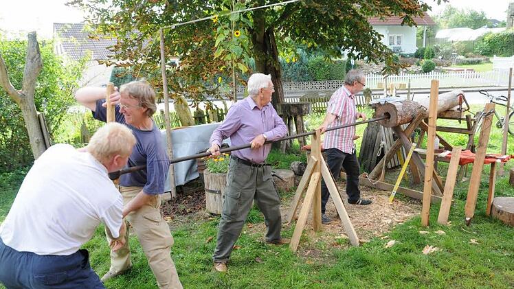 Mit viel Kraftaufwand waren die Mitarbeiter des Arbeitskreises "Heimat und Geschichte"mit dem Durchbohren des Stames beschäftigt, der jetzt den Erlebnisweg "Natour Haßberge" bereichert. Foto: Gerold Snater