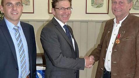 Zweiter B&uuml;rgermeister Alexander Wunderlich und Harald Maier (von links) gratulieren Klaus Biedermann. Foto: Werner Rei&szlig;aus