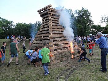 Die Kinder dürfen mit Fackeln den Holzstoß entzünden. Foto: Franz Galster