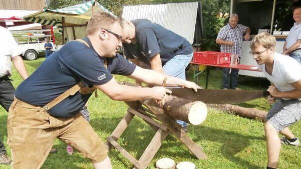 Mario Löffler (links) und Johannes Wachter mussten sich an der Ziehsäge ins Zeug legen, hier beobachtet von Klaus Dressel (hinten links) und Hans Josef Kopp. Foto: K.- H. Hofmann