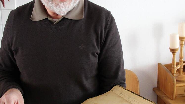 Hans Weiland blättert in alten Büchern der Sterbekasse HerzogenaurachFoto: Christian Bauriedel