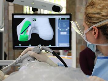 Eine Chirurgin des orthopädischen Krankenhauses Schloß Werneck zeigt, wie ein Oberschenkelknochen für ein neues Gelenk zurecht gefräst wird. Foto: Benedikt Borst