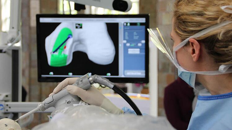 Eine Chirurgin des orthopädischen Krankenhauses Schloß Werneck zeigt, wie ein Oberschenkelknochen für ein neues Gelenk zurecht gefräst wird. Foto: Benedikt Borst