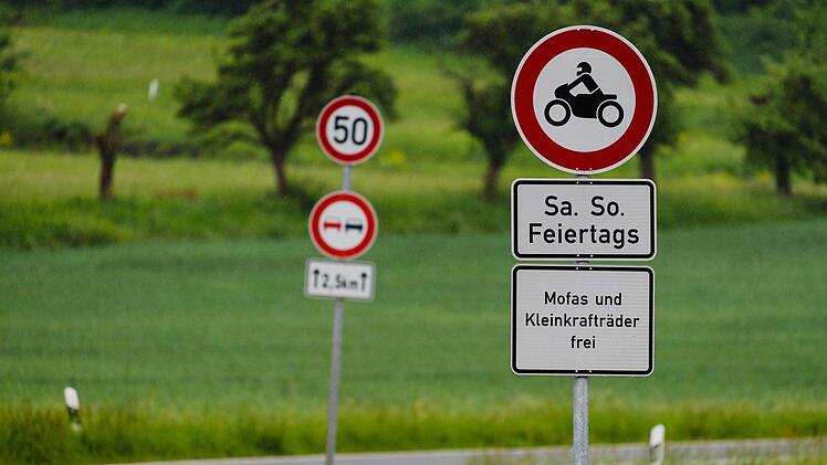 Bayern, Würgau: Vor dem Beginn des bei Motorradfahrern beliebten Streckenabschnitts Würgauer Berg sind Schilder angebracht, die Motorradfahrern an Wochenenden und Feiertagen die Weiterfahrt verbieten. Um Unfälle zu verhindern, hat die Polizei den Berg für Motorräder gesperrt. Foto: Nicolas Armer/dpa