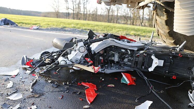 Kraftradfahrer kollidiert mit Traktor-Gespann und kommt zwischen Reifen zum Liegen