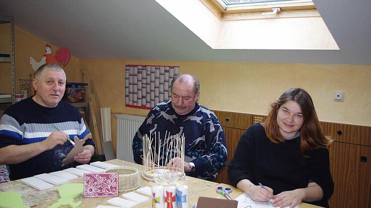 Die Bewohner im Haus Fischbachtal laden zum Osterbasar ein. Peter (links) bemalt Holz-Osterhasen, Siegfried ist mit der Herstellung eines Osterkörbchens beschäftigt und Claudia fertigt in Linolschnitt schöne Karten an.  Foto: Karl-Heinz Hofmann