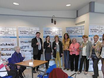 "Der Kreuzberg in der Rhön - Gelebter Glaube", diese Ausstellung von Regina Rinke (2. v. r.) wurde in der Georgi-Kurhalle eröffnet. Interessierte Besucher, unter ihnen auch Bürgermeisterin Brigitte Meyerdierks (3. v. r.), erhoben mit der Ausstellerin das Glas. Foto: Stadt Brückenau