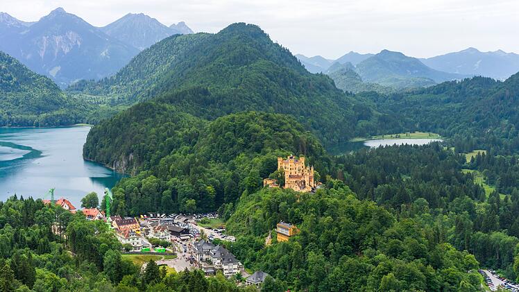 Luftaufnahme vom Aussichtspunkt auf dem Weg zum Schloss Neuschwanstein mit Blick auf das Schloss Hohenschwangau und den See in Schwangau Aerial view from view point on the way to Neuschwanstein castle with scenery of Hohenschwangau castle, lake in schwangau town