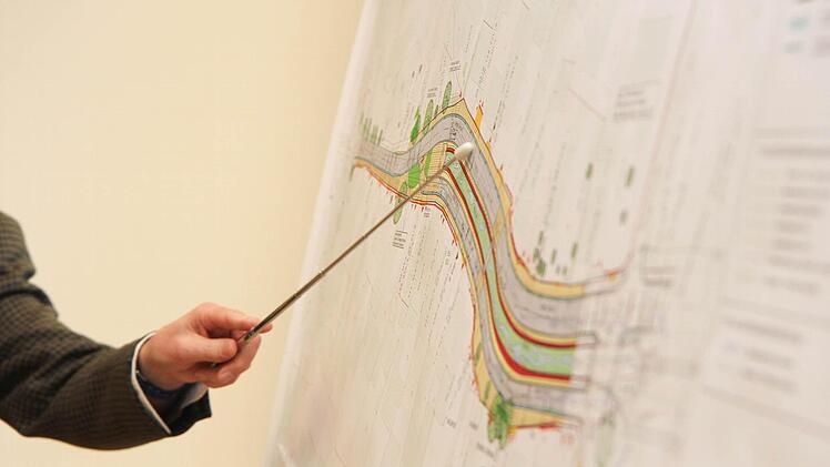 Planer Ingo Jakobsen erläutert das Bauvorhaben "Weide" zwischen Bahnlinie (rechts) und Schweinfurter Straße. Das hellgrüne Band stellt den Mühlbach zwischen den Straßenhälften dar.  Foto: Michael Gründel