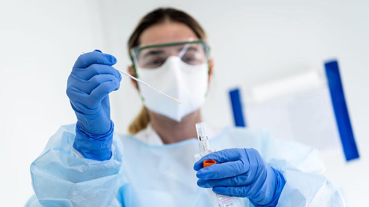 Mittels eines Abstrichs können Menschen auf das Coronavirus getestet werden.  Symbolbild: Jean-Christophe Bott/dpa