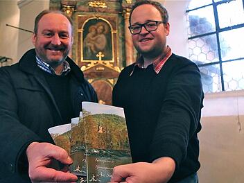 Pfarrer Paul Kowol (links) und Verfasser Michael Rotschedl präsentieren den Kirchenführer in der St. Cyriakus-Kirche Morlesau.  Foto: Gerd Schaar