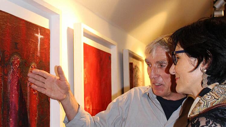 Günter Rocznik erklärt einer Besucherin sein Bild "Reise nach Nordrhein-Westfalen"