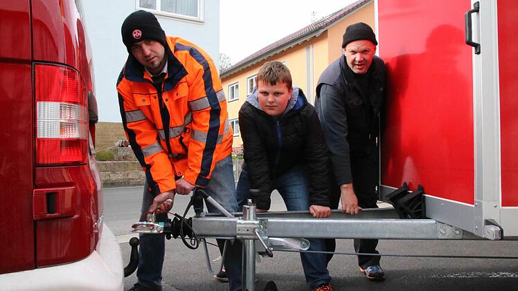 Wenn die Kleinbracher Feuerwehr zum Löscheinsatz ausrückt, muss sie erst den eineinhalb Tonnen schweren Anhänger ankuppeln. Das führen hier (von links) Philipp Schlereth, Louis Pörtner und Christoph Kreps vor. Foto: Ralf Ruppert