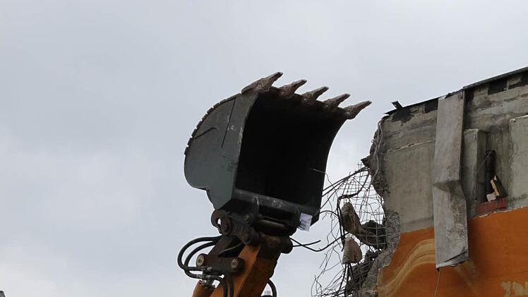 Der Bagger knabbert an der Seitenwand des ehemaligen Schwimmbades. Foto: Mäuser