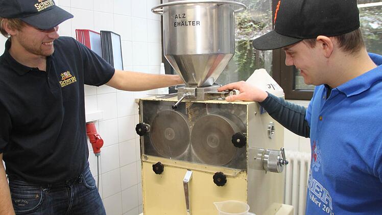 Anschließend wandert das Malz in die Schrotmühle. Thomas Wild (links) und Felix Zirnsack schroten 15 Kilo für einen 100-Liter-Sud.