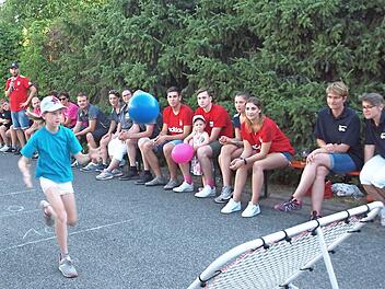 Ein Mädchen der Igel-Kids fängt den auf das Trampolin geworfenen und von dort zurückspringenden Ball (links). Rechts transportiert ein Mädchen der Kids des Bayern Fanclubs geschickt einen Becher mittels eines aufgeblasenen Luftballons. Fotos: Alfred Thieret