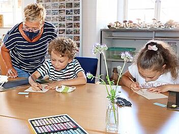 K&uuml;nstlerin Elfriede Dauer leitet die Kleinen beim Malen an.