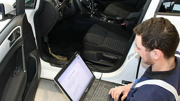 Kfz-Mechatroniker Daniel Baumann schlie&szlig;t ein Diagnoseger&auml;t im Auto an. Vom Abgas-Skandal betroffene Dieselfahrzeuge m&uuml;ssen umprogrammiert werden. Foto: Ronald Heck