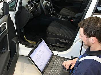 Kfz-Mechatroniker Daniel Baumann schließt ein Diagnosegerät im Auto an. Vom Abgas-Skandal betroffene Dieselfahrzeuge müssen umprogrammiert werden. Foto: Ronald Heck